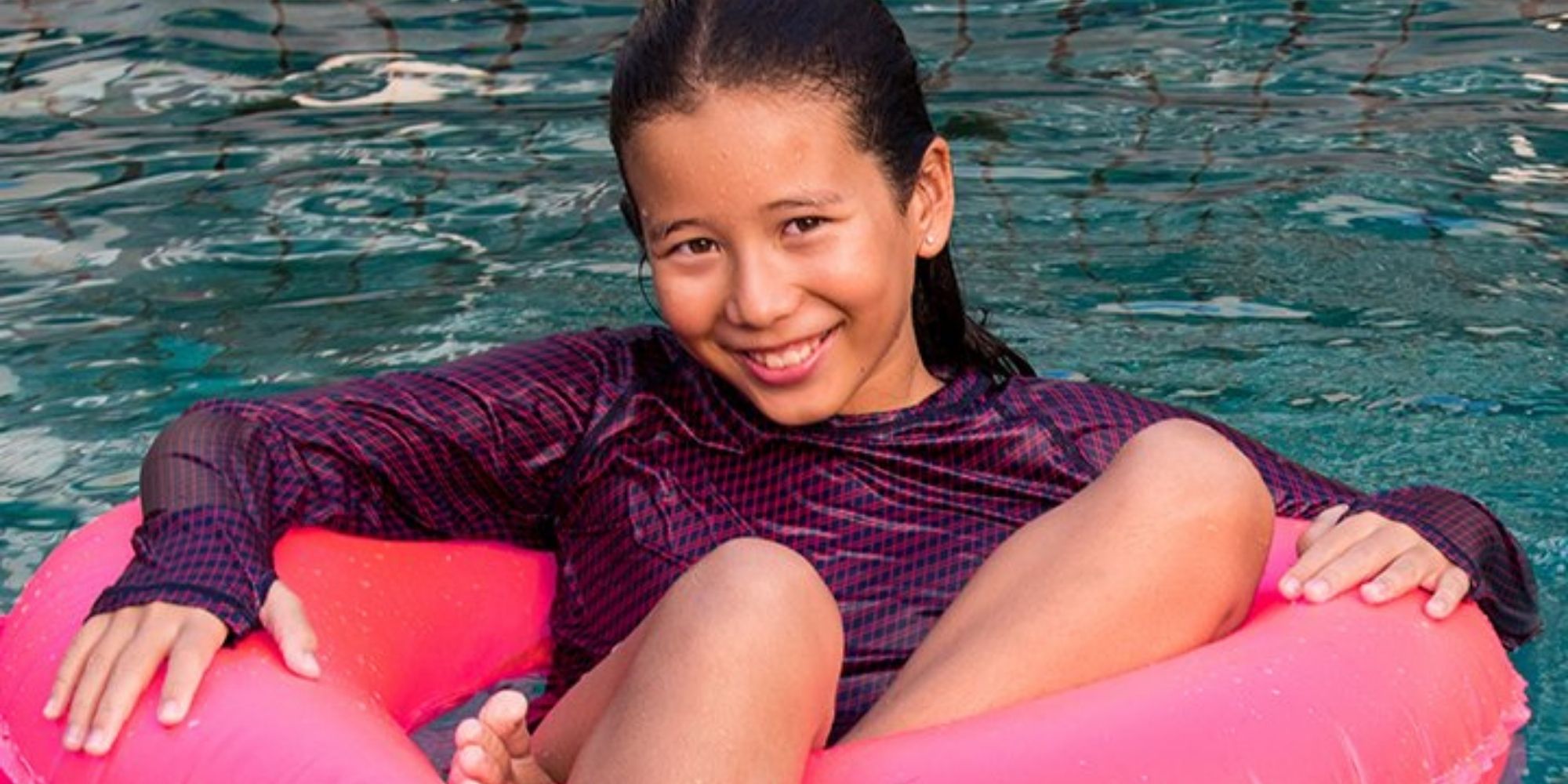 child wearing purple patterned sustainable kids rashguard by Loop Swim