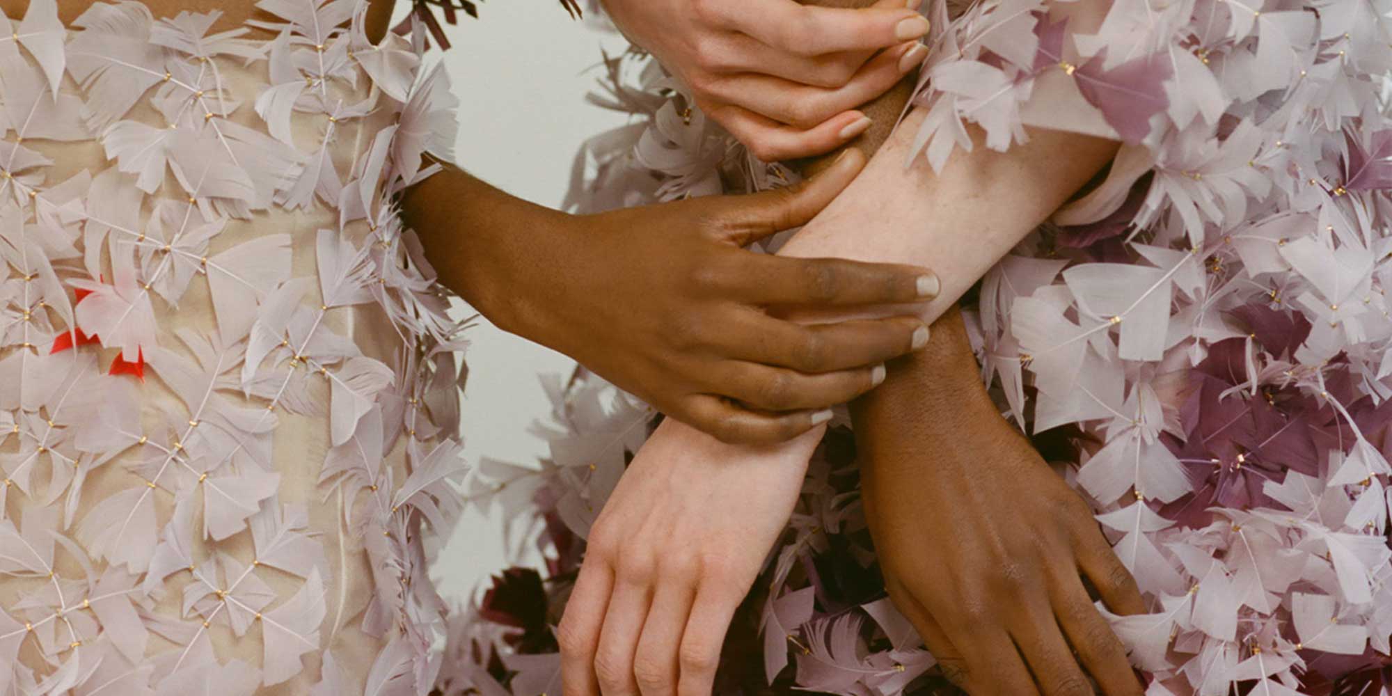 hands grasping across feathered dress from sustainable fashion online course about luxury fashion