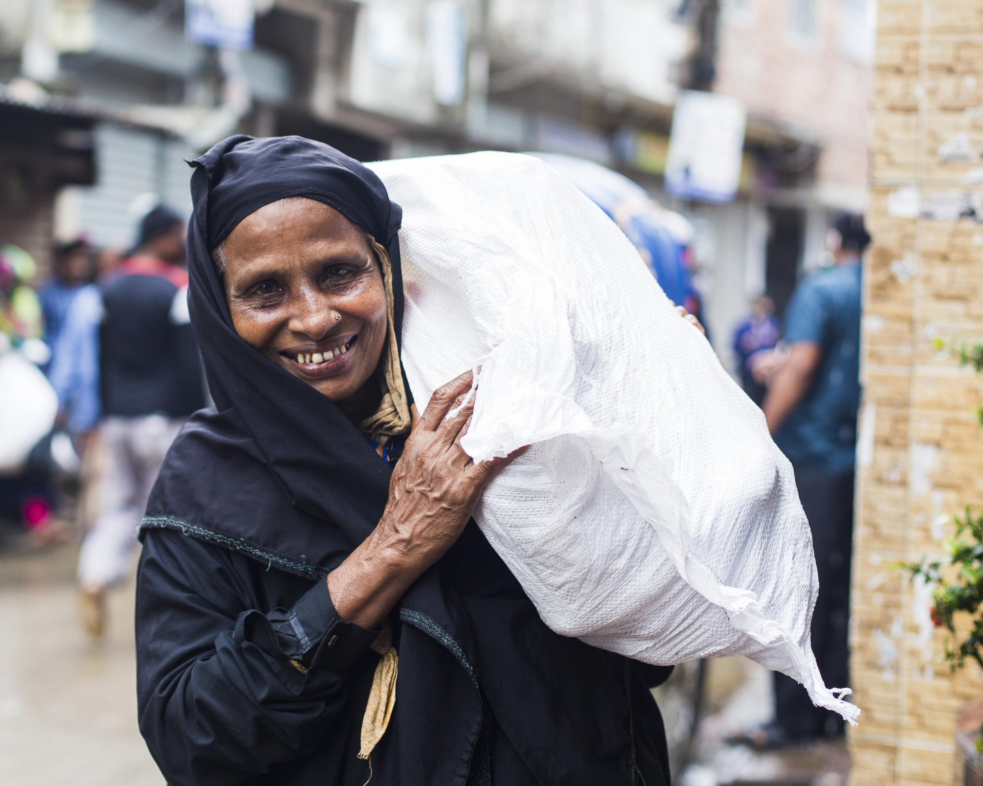 Bangladeshi worker holding bag of garments for SAJIDA foundation and Lost Stock