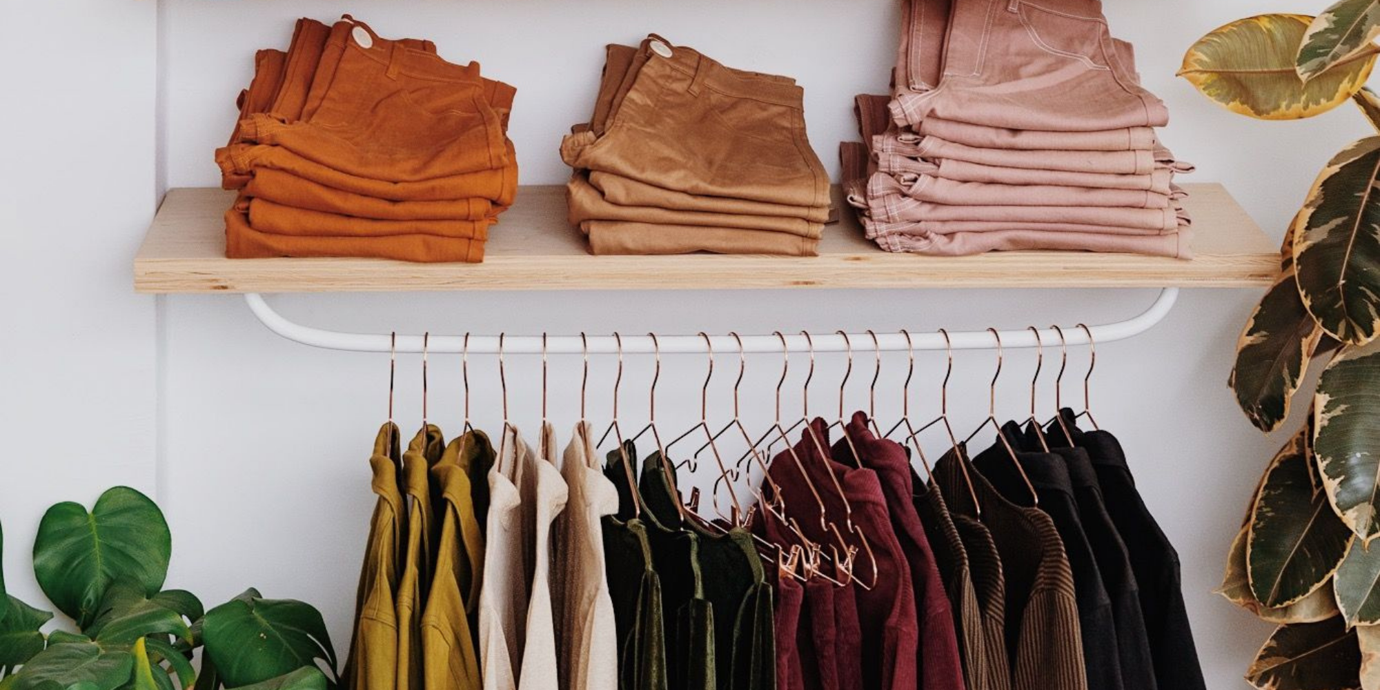 a shelf and rack with colourful seasonal sustainable garments by Whimsy + Row