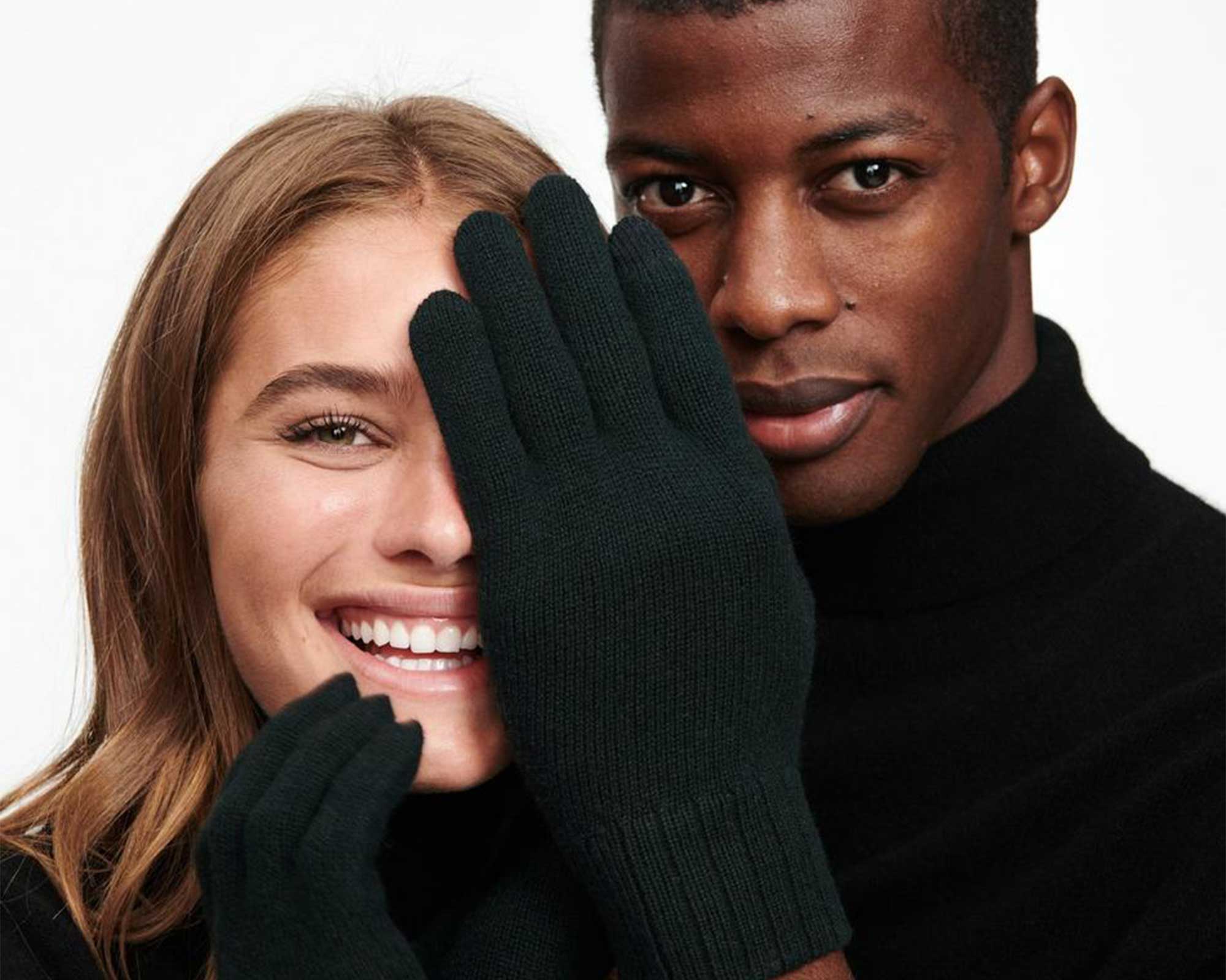 man covering woman's eyes with dark green sustainable glove