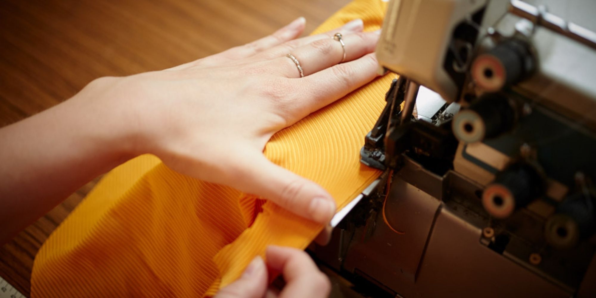 Elle Evans seamstress and founder making yellow sustainable activewear on her sewing machine