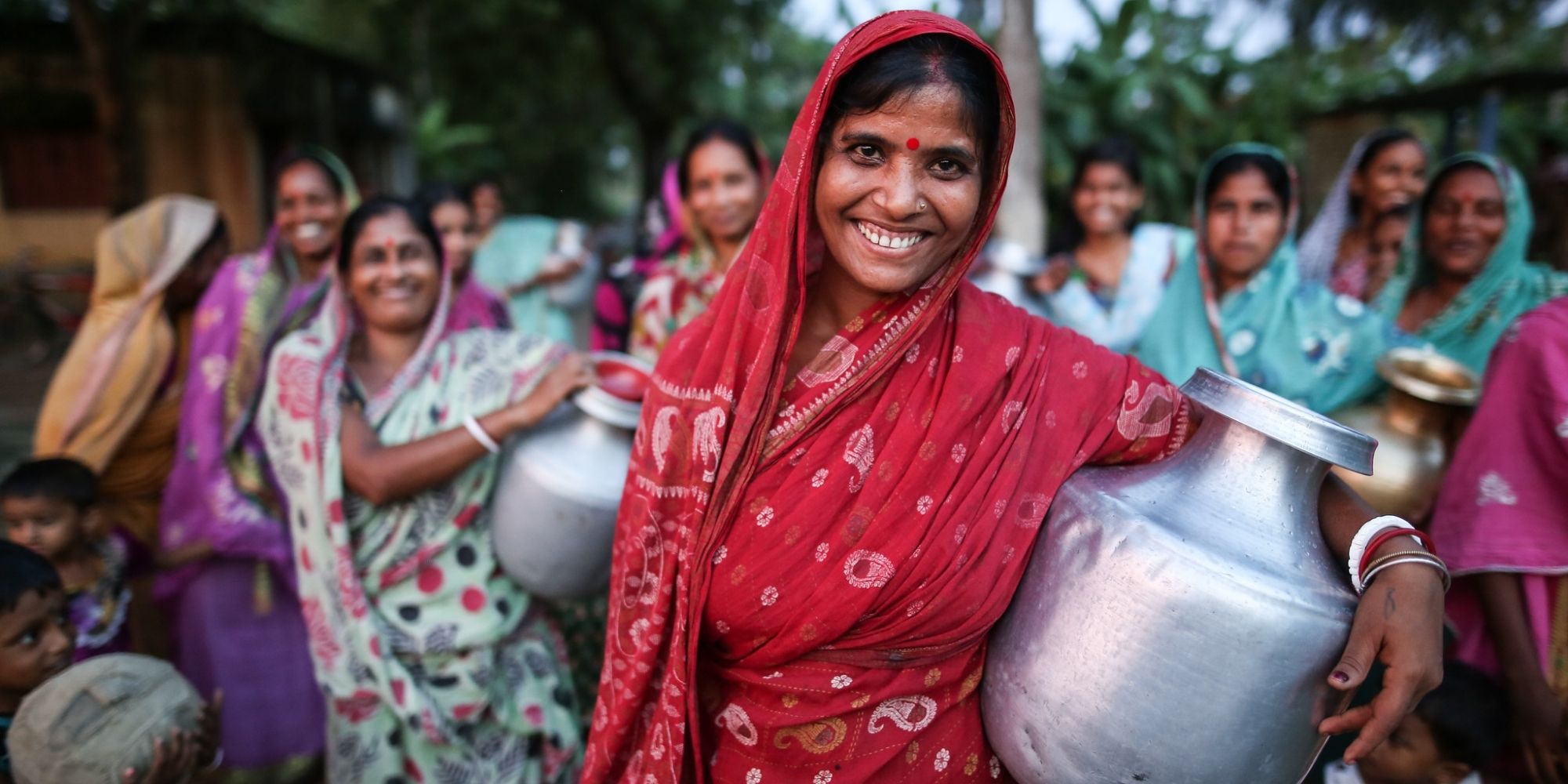group of women in saris holding water containers thanks to Water For People charity