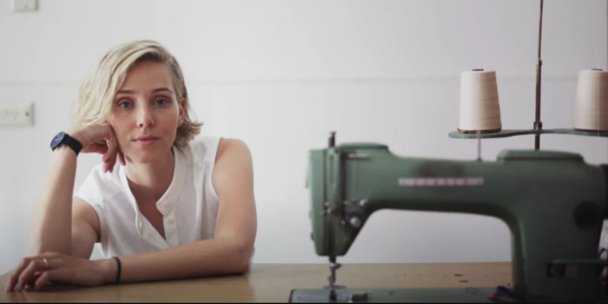 A.BCH founder Courtney Holm sitting next to sewing machine