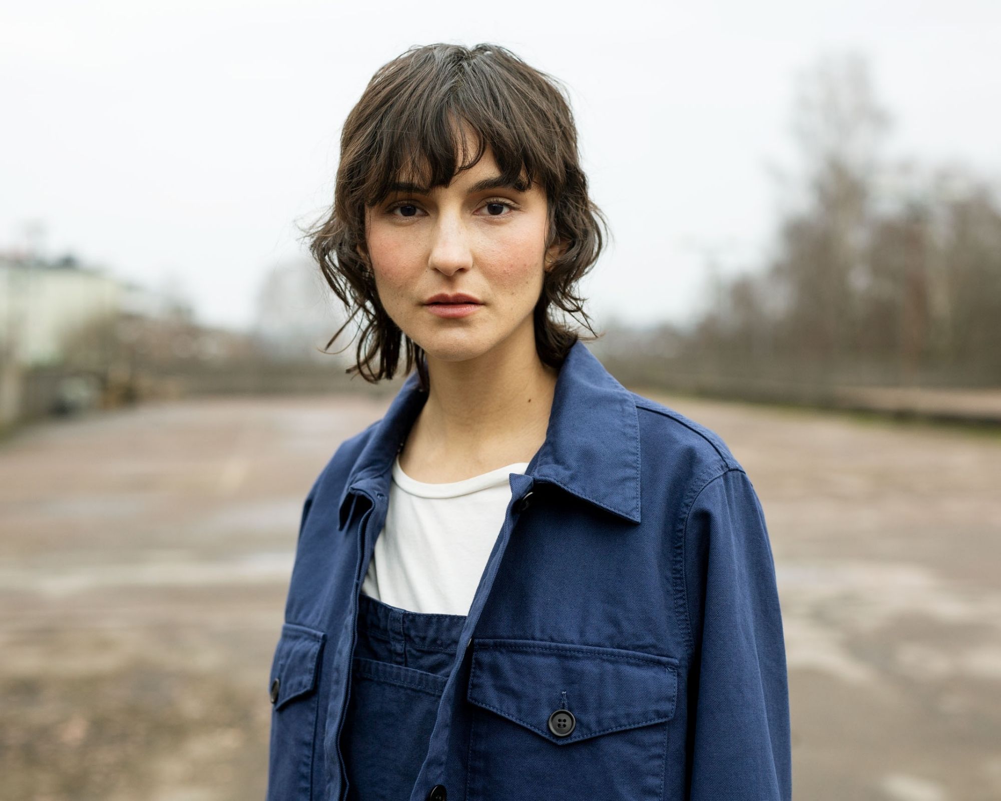 woman wearing blue workwear jacket by eco brand Nudie Jeans