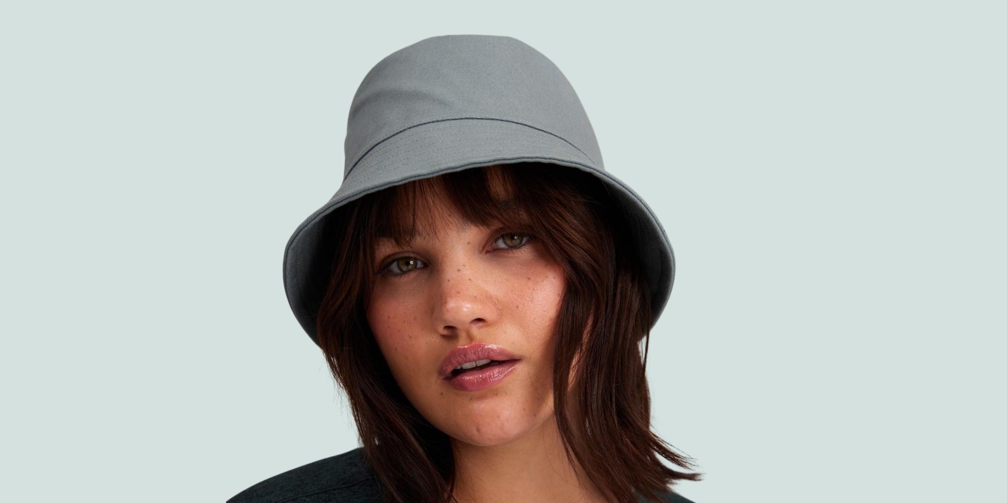 woman wearing grey recycled bucket hat by Girlfriend Collective