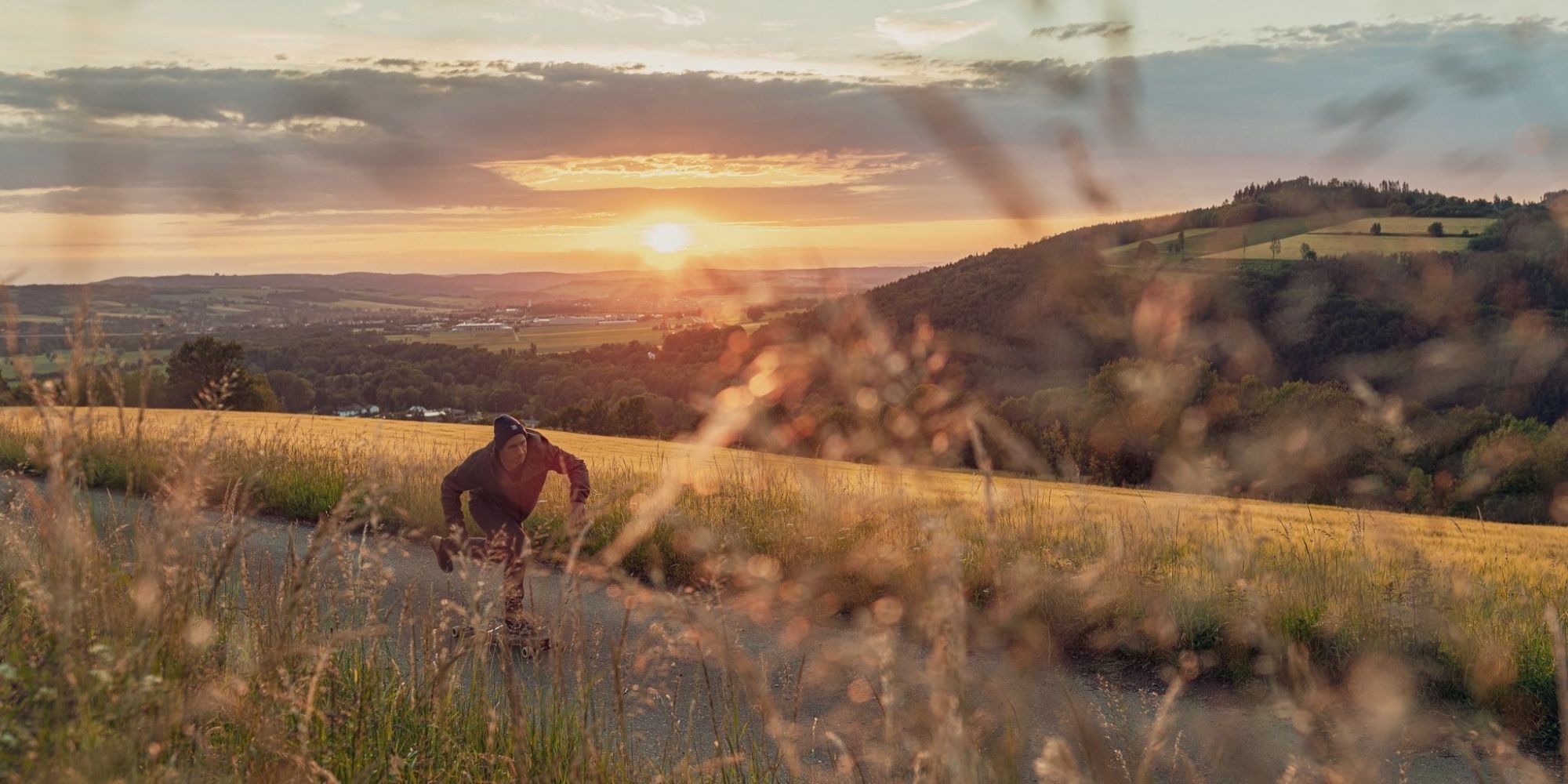 skater wearing ethically made bleed clothing on country road during sunset