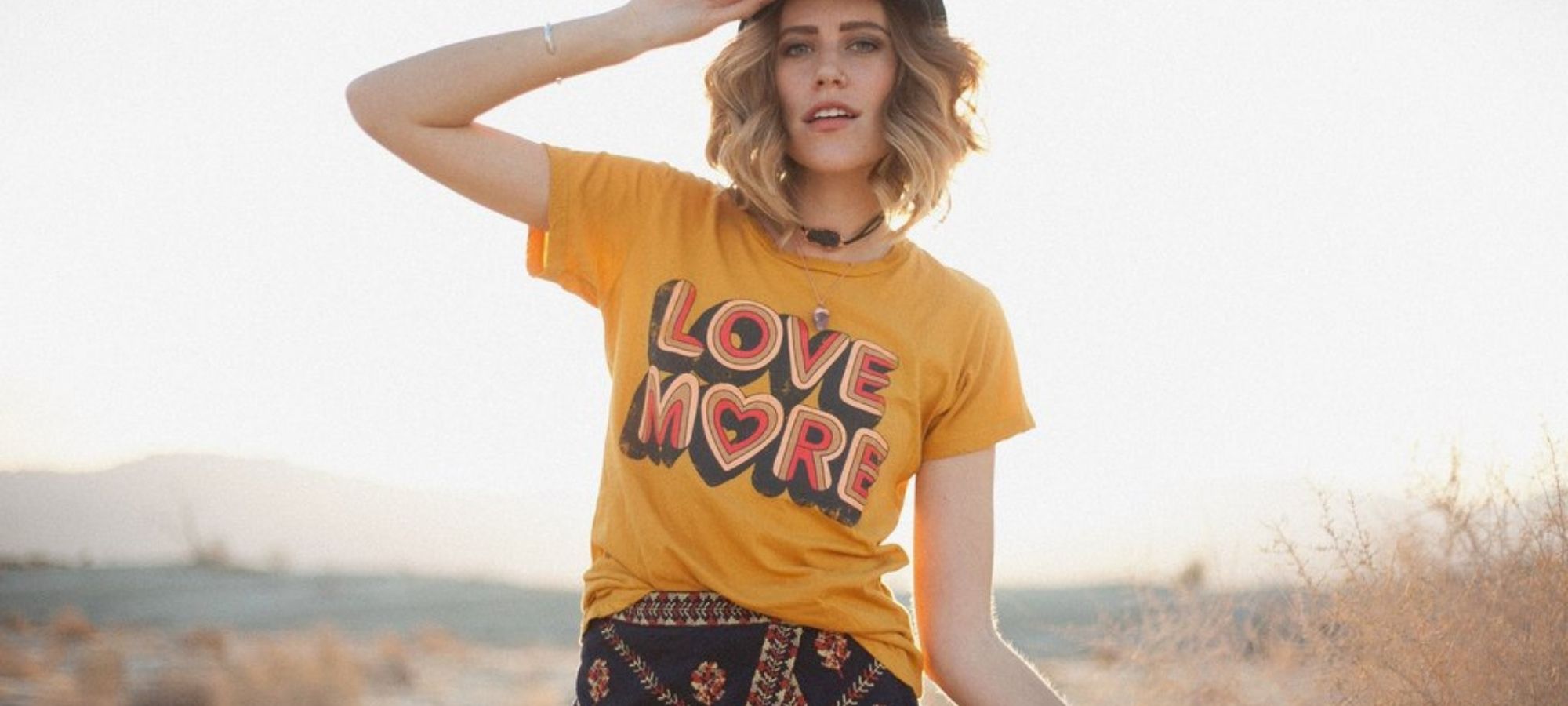 woman wearing logo yellow ethical tshirt by Dazey LA