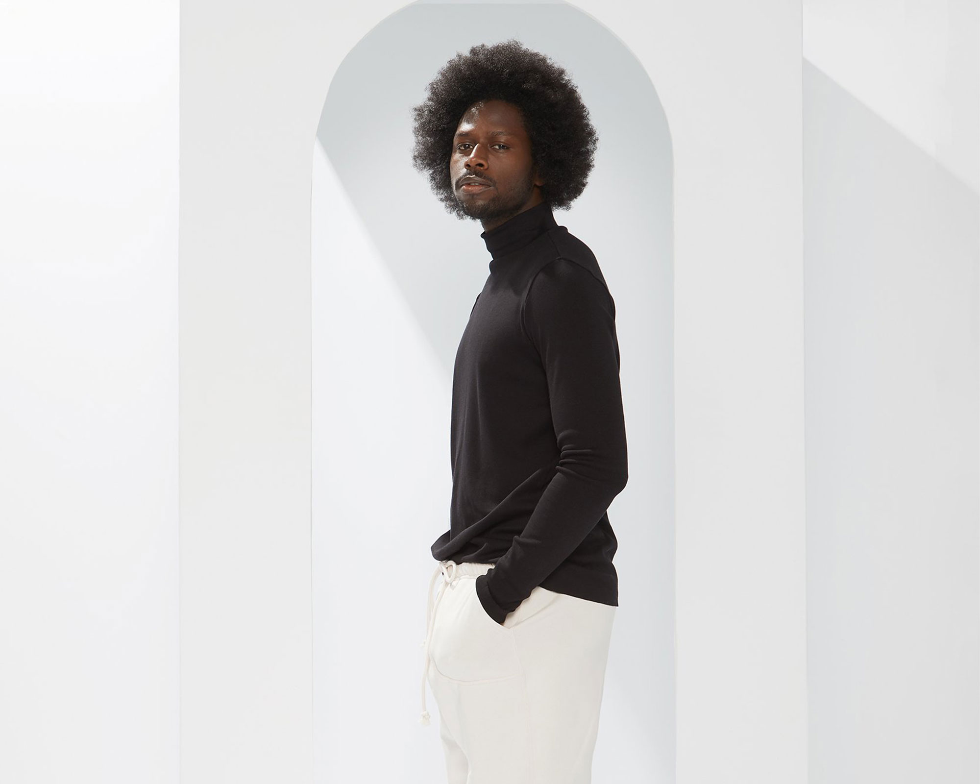 black man with afro wearing black mock neck skivvy made sustainably by A.BCH