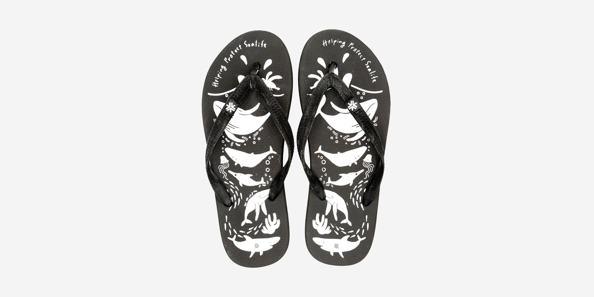 Top down view of black eco-rubber thongs with white sea creature print by Australian brand Etiko.
