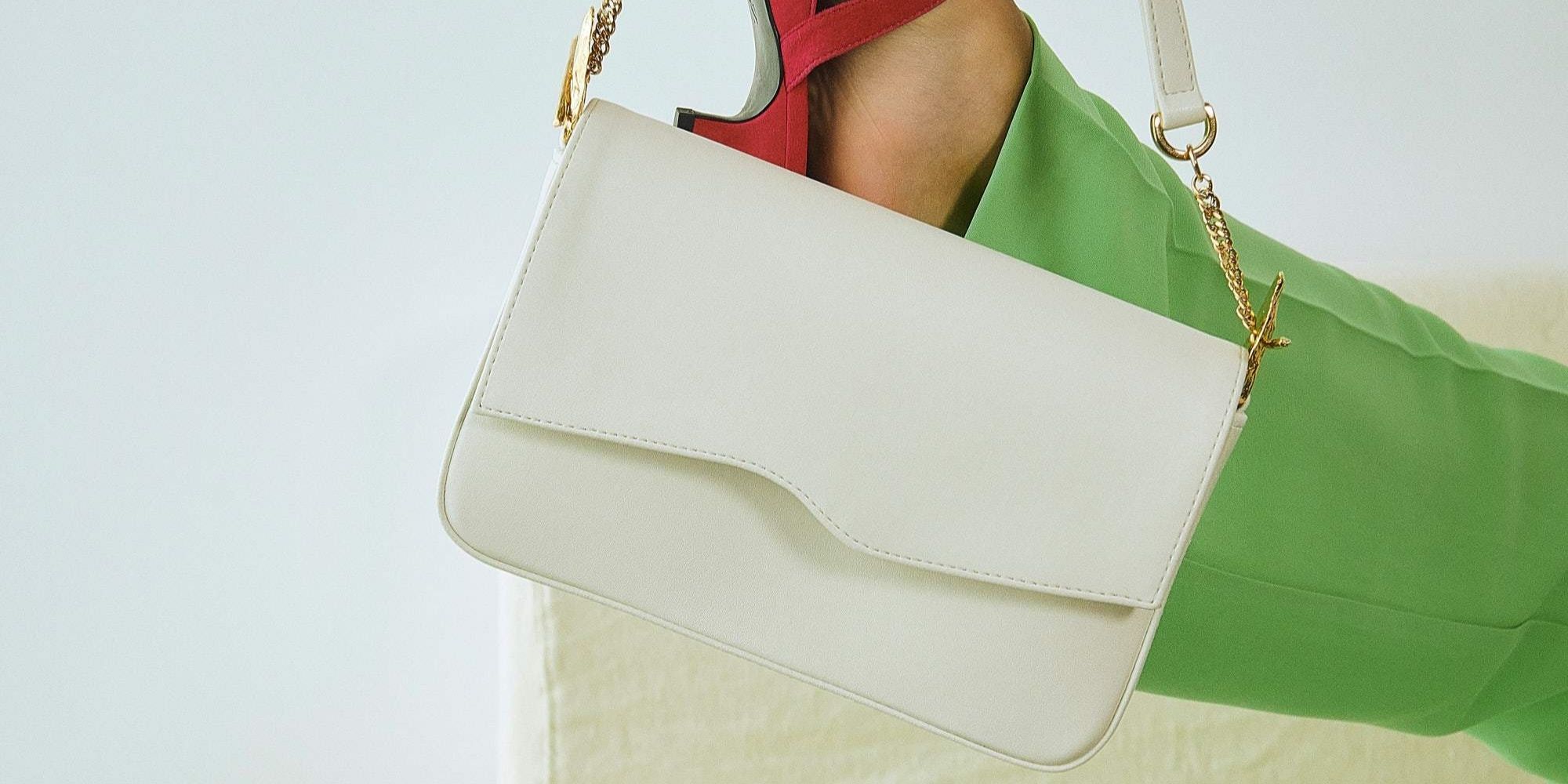 Person with white vegan luxury bag made by Mashu hanging off their foot.