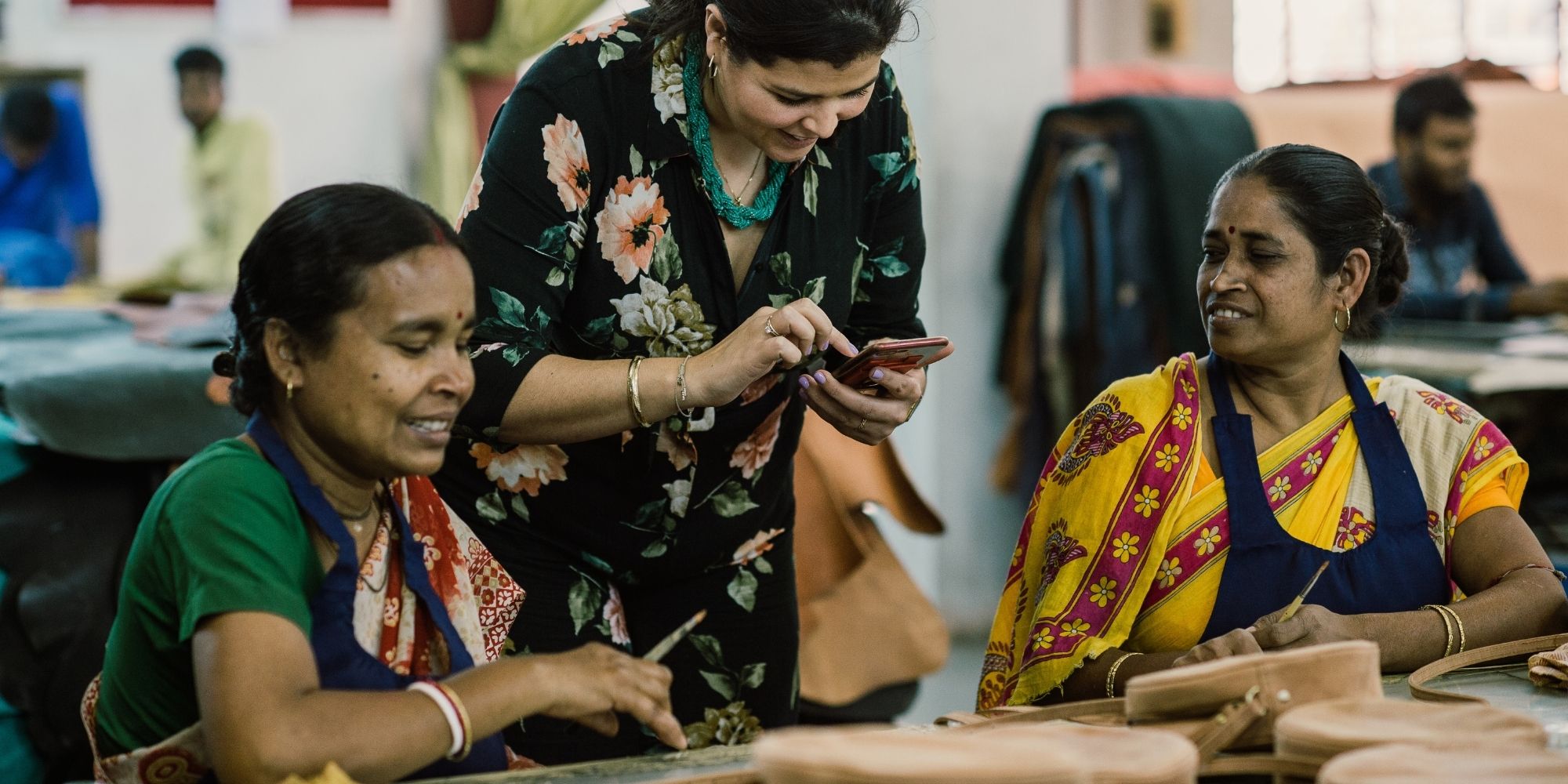 Group of female garment workers in front of a table of O My Bag bags.