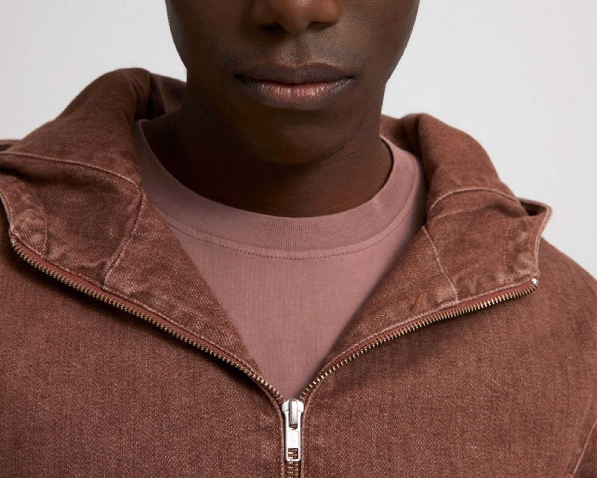 Close up of a deep pink jacket and t-shirt naturally dyed with plant leftover by Armedangels.