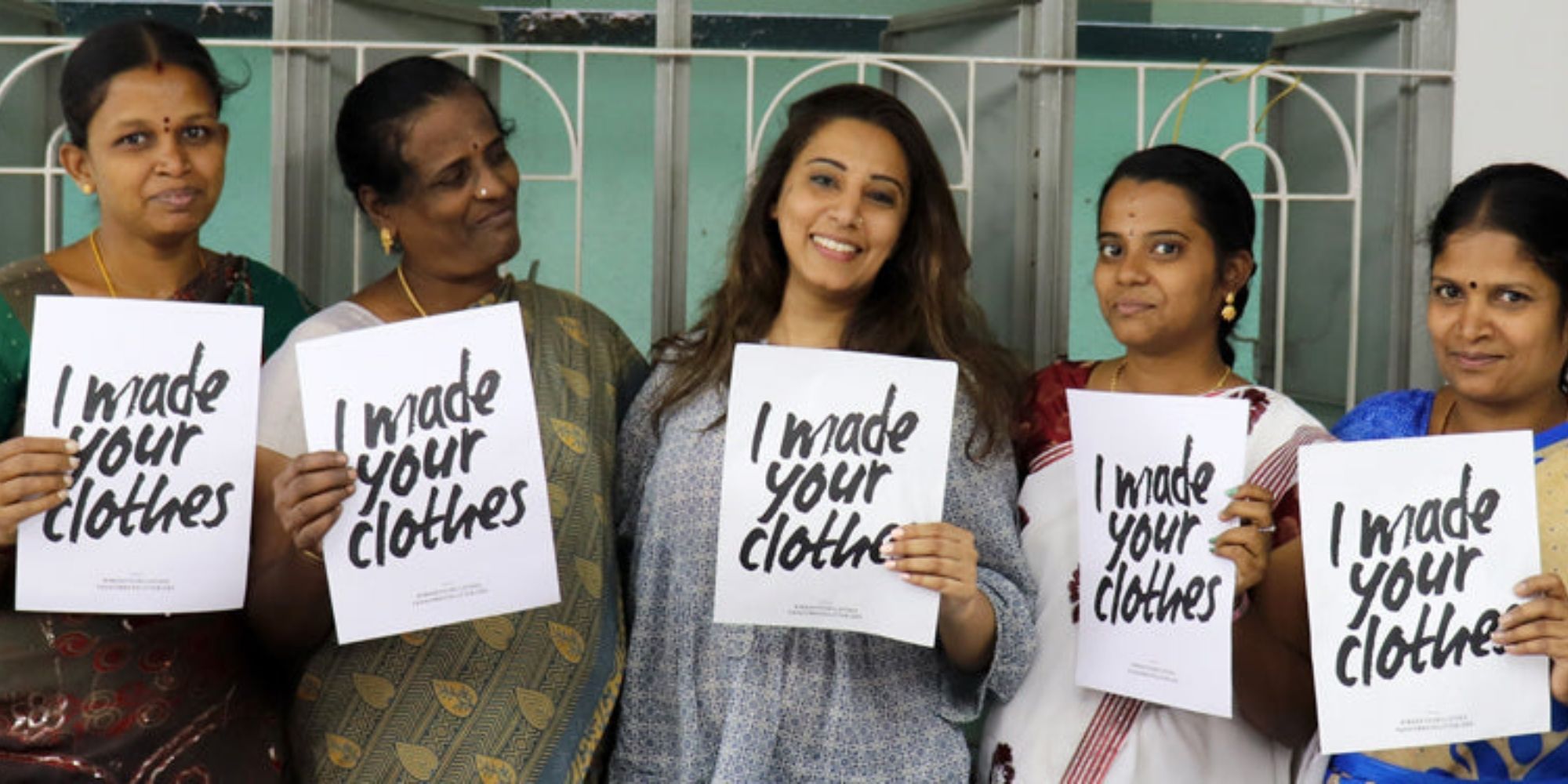 The Good Tee founder Adila Cokar and four garment workers holding up Fashion Revolution