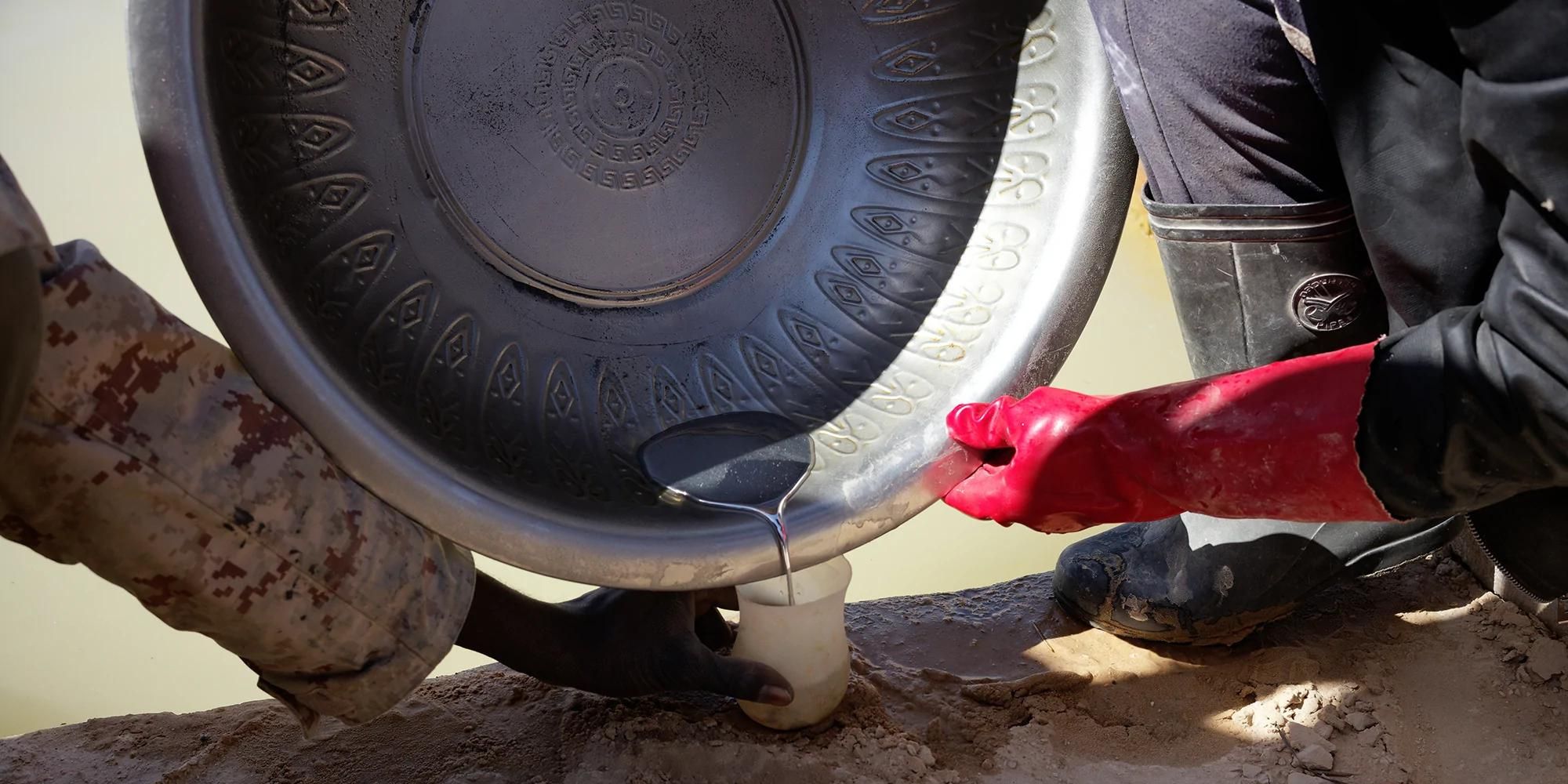 Gold workers pouring mercury to separate gold from debris.