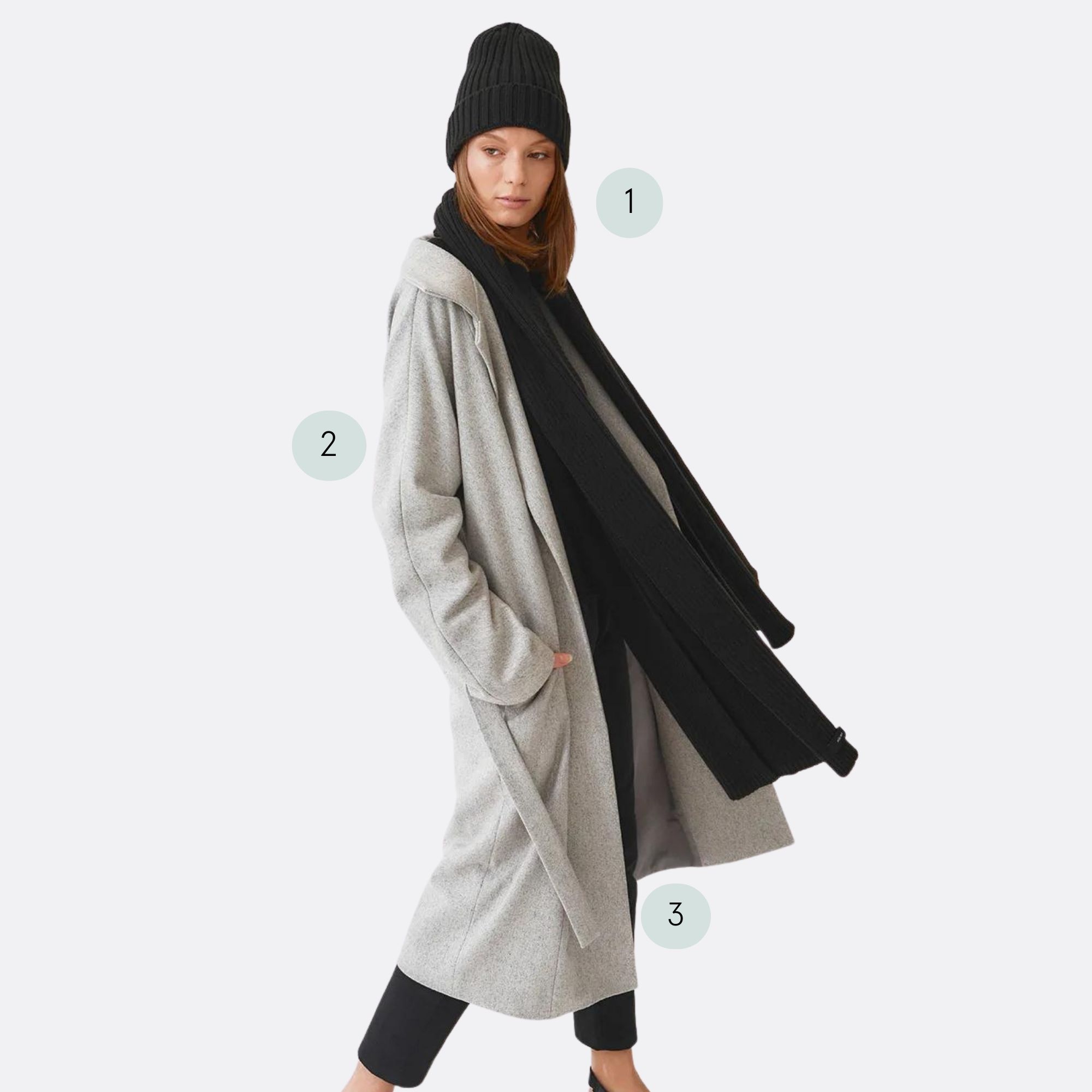 A black beanie and scarf set with a grey recycled trench coat and black pants by Mila.Vert.