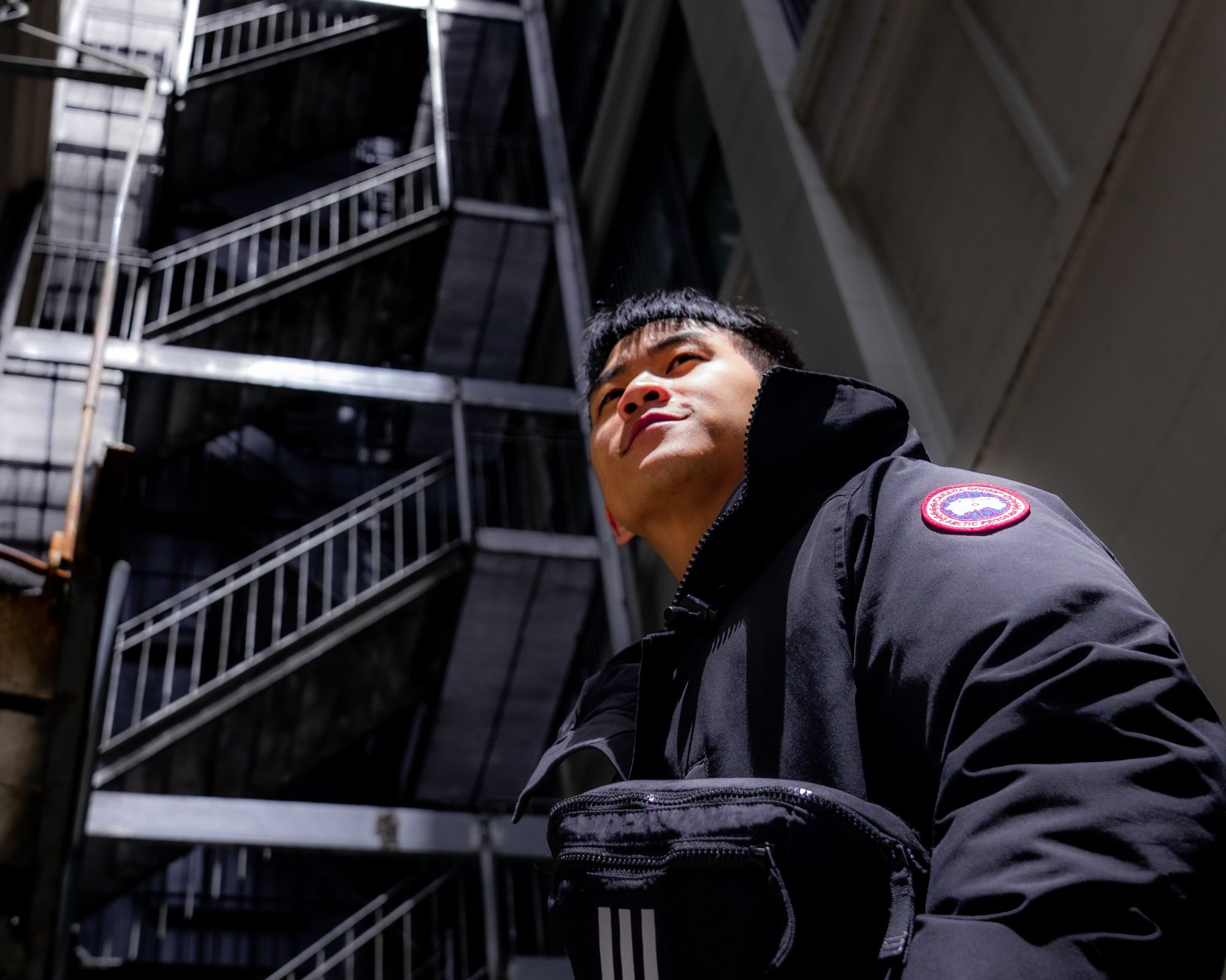 Someone wearing a black Canada Goose branded puffer jacket.
