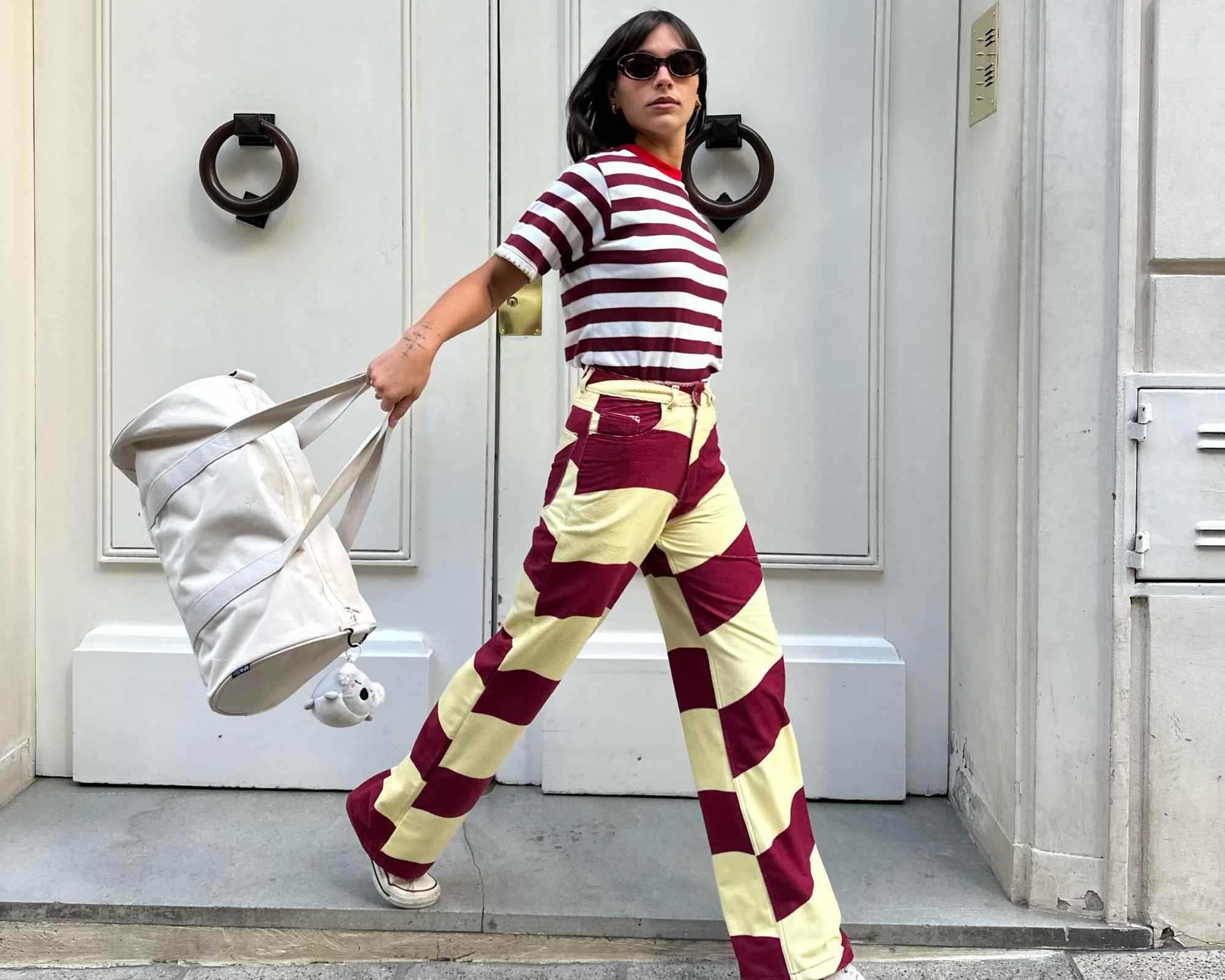 person wearing striped pants carrying weekender duffle bag from lefrik
