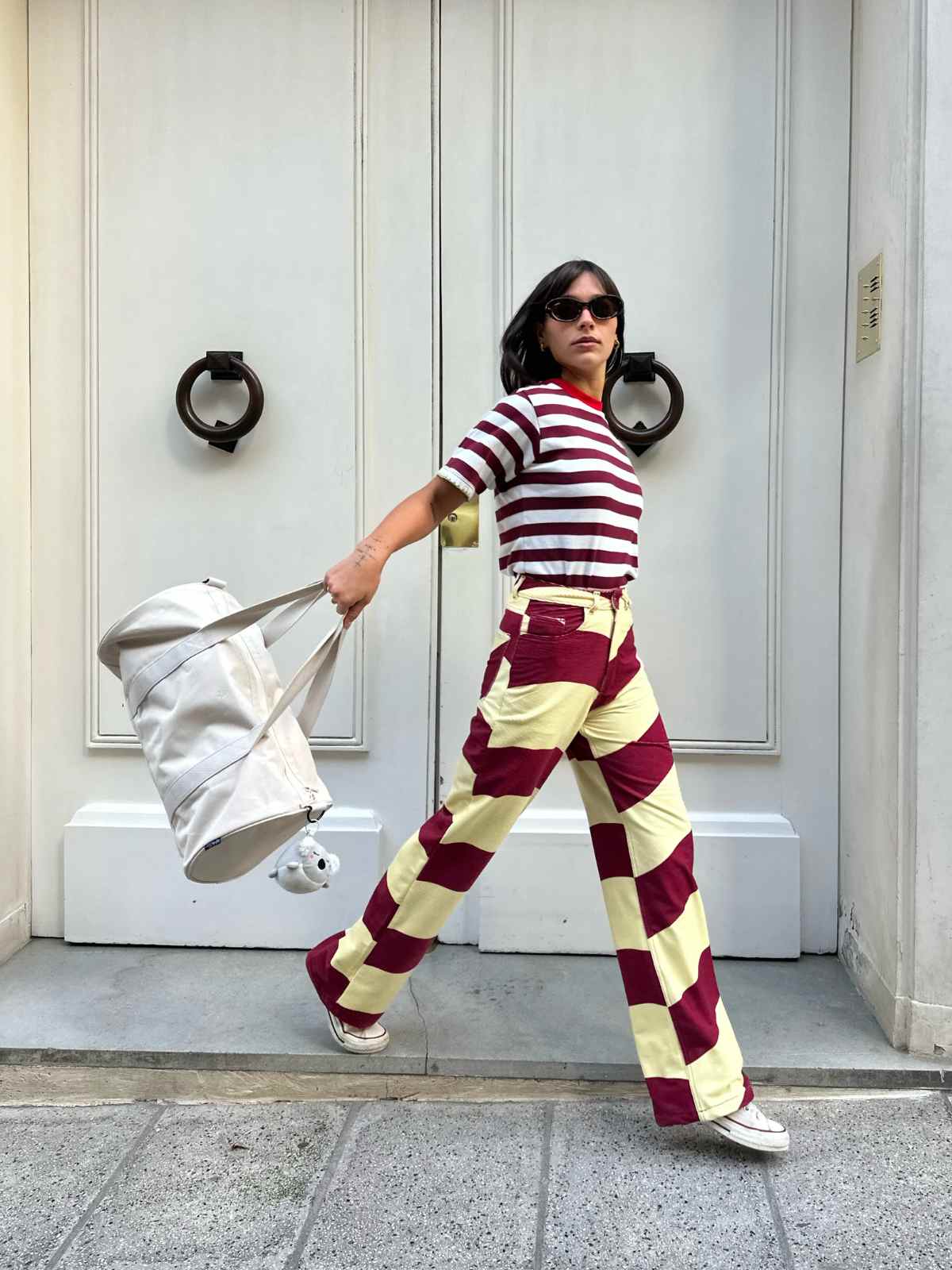 person wearing striped pants carrying weekender duffle bag from lefrik